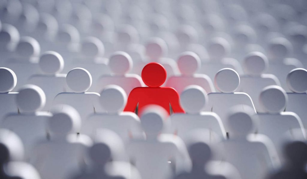 Red-plastic-figure-sticking-out-in-a-sea-of-white-plastic-figures-symbolizing-the-importance-of-marketing-strategy-in-standing-out-from-your-competitors.