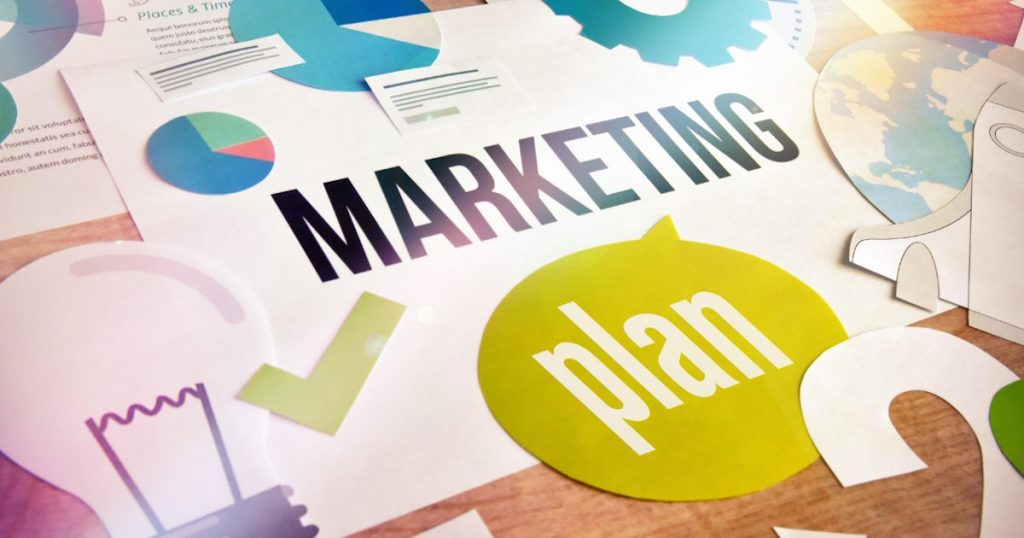 Marketing plan concept design laid out on a desk with the words “marketing plan” in the center
