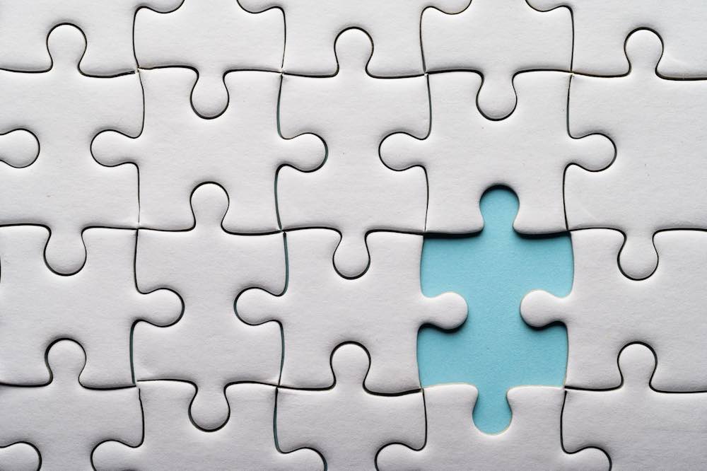 Jigsaw puzzle with missing piece to be filled by a fractional vs. full-time CMO.
