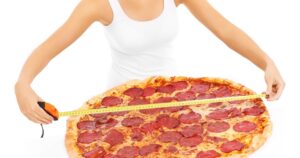 Woman measuring a huge pizza representing fractional vs. full-time CMOs